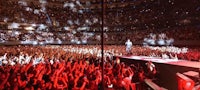 a man in a red shirt is standing in front of a large crowd