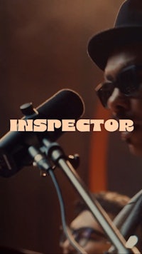 a man in a hat and sunglasses is singing into a microphone